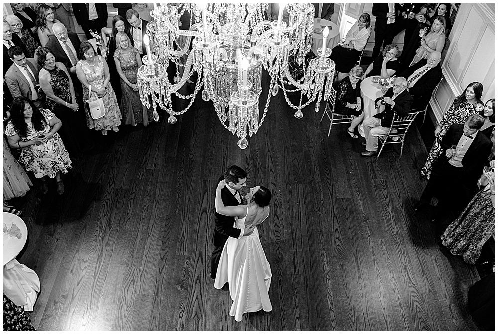 What is a fine art wedding photographer? | Atlanta fine art wedding photographer serving Georgia and beyond | Black and white photo of a bride and groom first dance from a balcony view with guests looking on