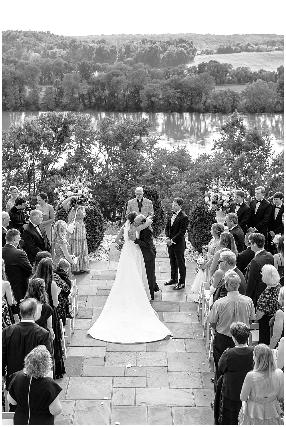 Fine Art Luxury Wedding Photographer in Atlanta | A black and white bird's eye drove photography view of a bride hugging her father at the altar at her wedding ceremony as he hands her off to be married