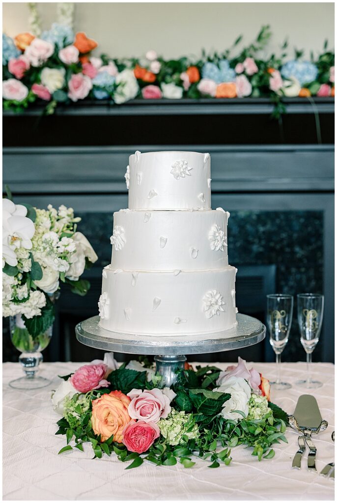 Elegant white wedding cake with simple floral piping and colorful spring florals at a Berkeley Hills Country Club wedding reception
