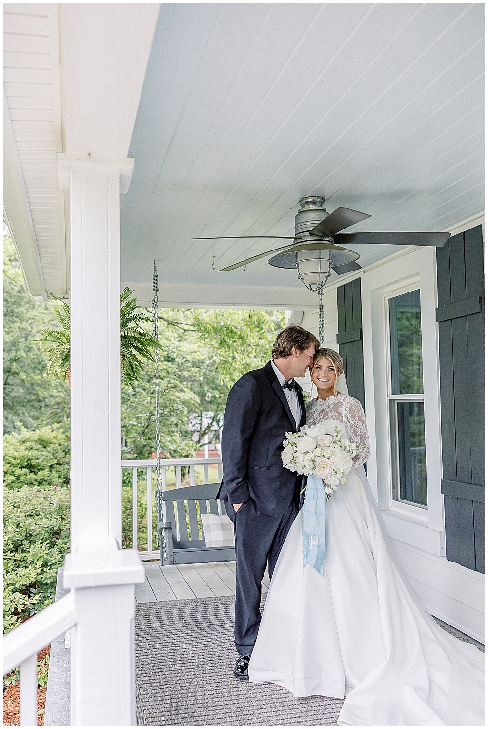 Bride and groom pose for portraits under a porch on their rainy wedding day in Georgia | Atlanta wedding photographer