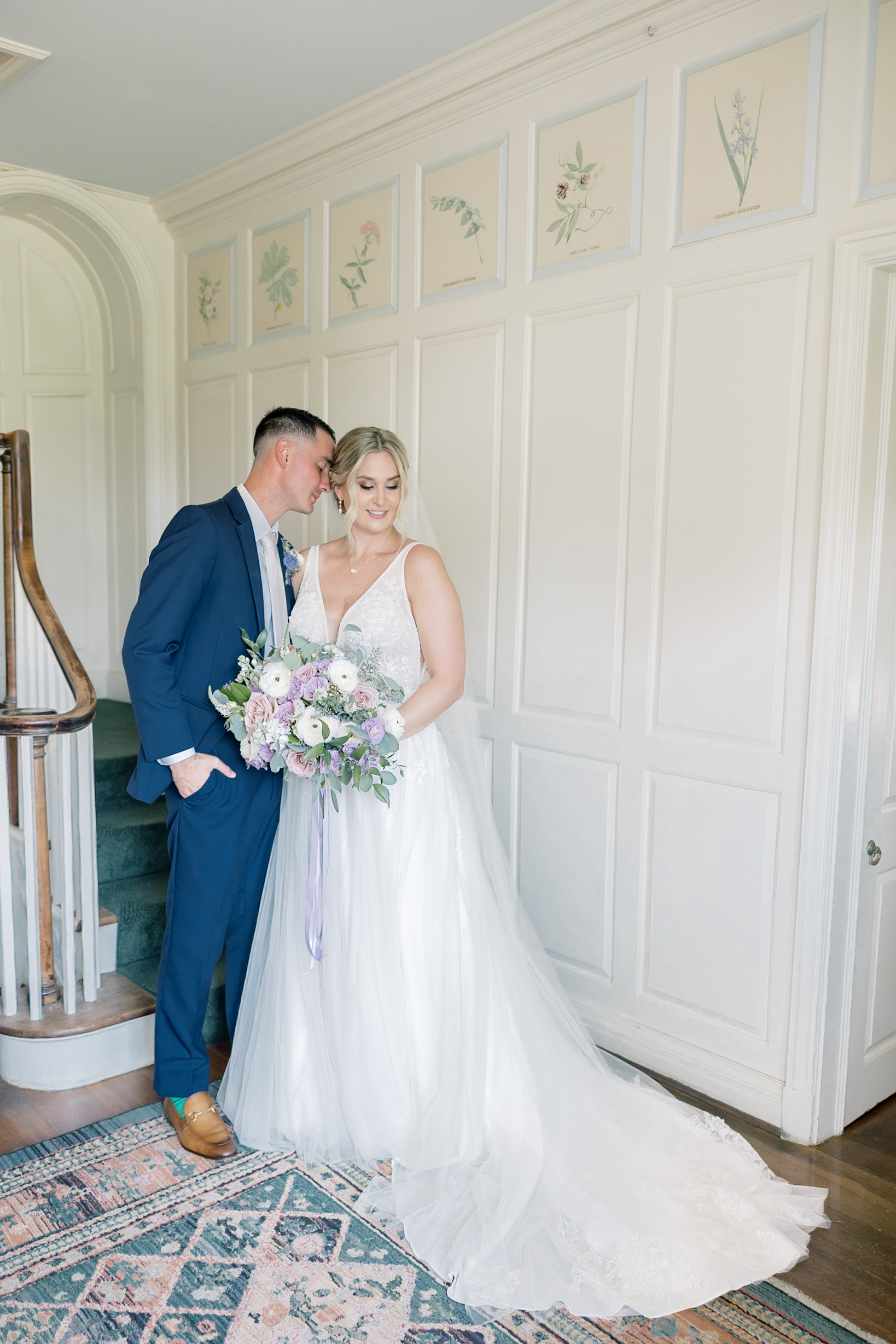 A bride (dressed in an A-line lace wedding dress) and groom (in a navy blue suit) posing for a romantic portrait indoors on a hot summer wedding day in Georgia, taken by an Atlanta wedding photographer with a film-inspired editing style.